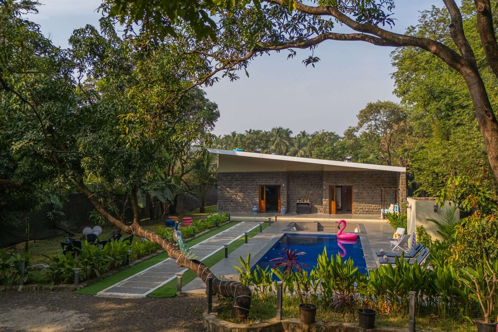 A stone-clad EkoStay villa with a private pool set among mature trees